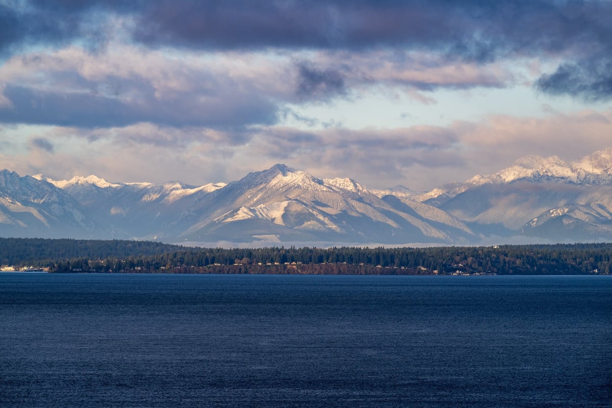 Mountain peaks under a pale winter sky with low cloud