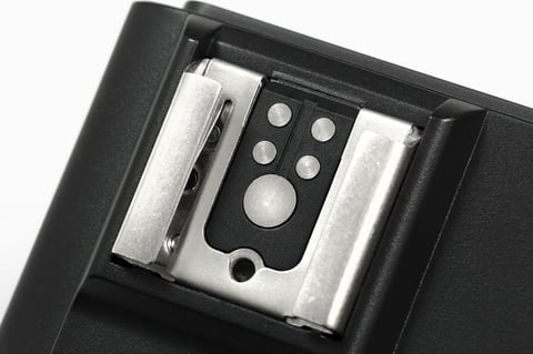 A close-up of a DSLR hot shoe mount or flash trigger on a white background. Photography equipment.